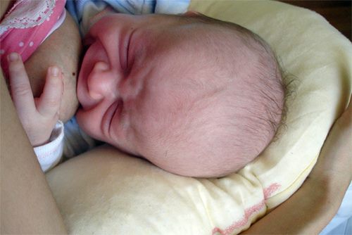 Baby græder ved brystet