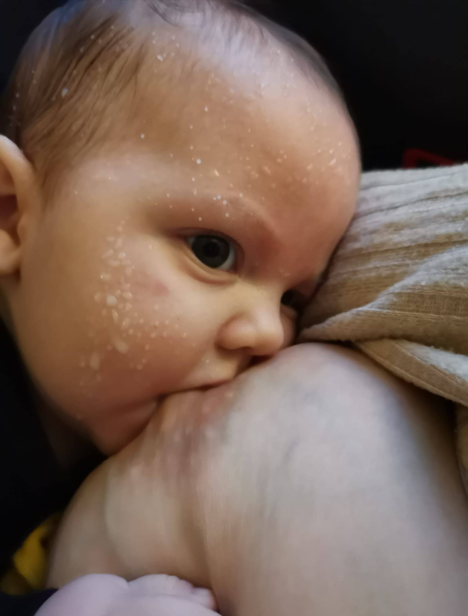 Baby med mælkesprøjt ved brystet