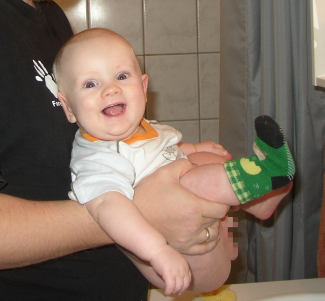 Baby holdes over håndvask under afføring